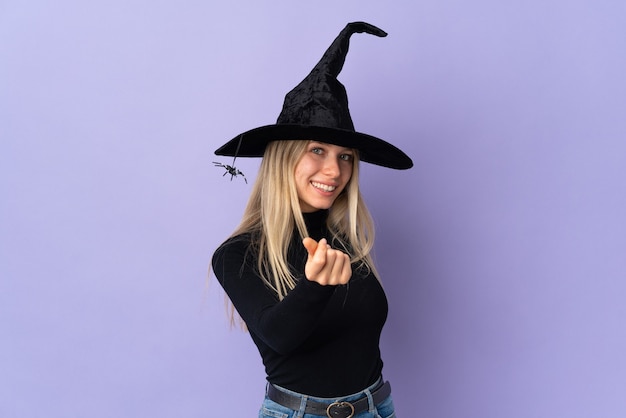 Chica joven en traje de Halloween sobre pared púrpura