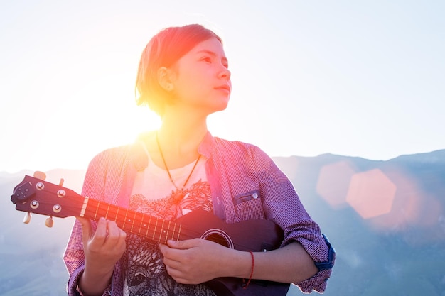 Chica joven con ukelele en pasarela