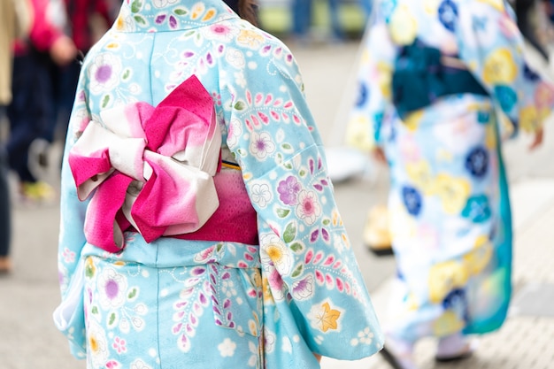 Foto chica joven vestida con un kimono japonés parado frente al templo sensoji en tokio