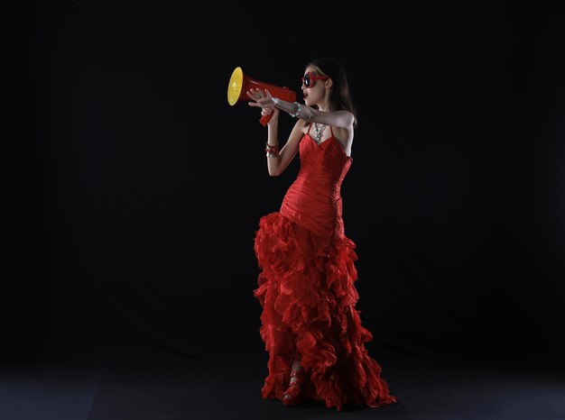 chica joven en un vestido rojo con un megáfono