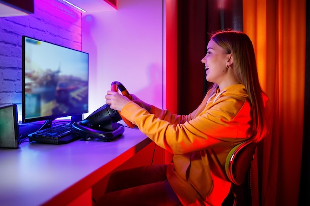 Chica jugadora jugando carreras en una computadora Ella usa un juego emocional del volante