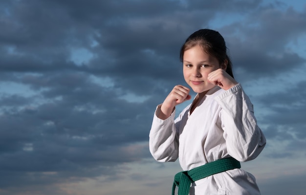 Chica de jujitsu en kimono sobre fondo de cielo