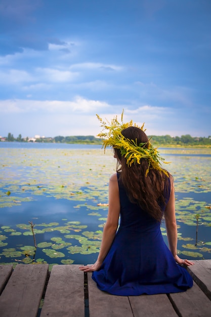 Chica junto al lago con una corona en la cabeza