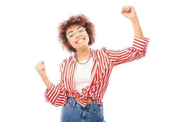 Chica kazaja afortunada positiva con peinado afro riéndose se regocija celebrando la victoria escuchó buenas noticias aisladas en fondo blanco