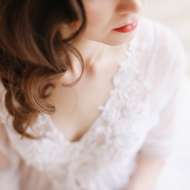 Chica con labios rojos de perfil. Retrato de primer plano de una mujer joven. Detalles de la boda. Mañana de la novia.