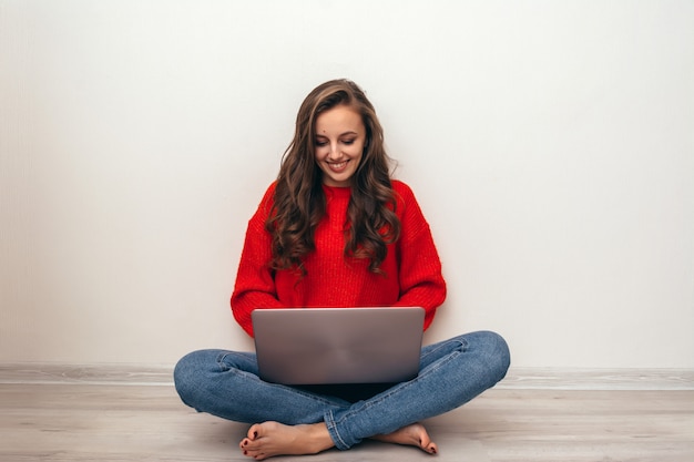 Chica con laptop en casa.