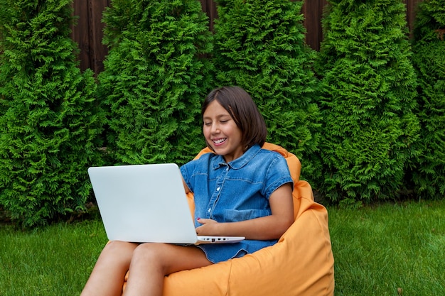 Chica con una laptop en el jardín.