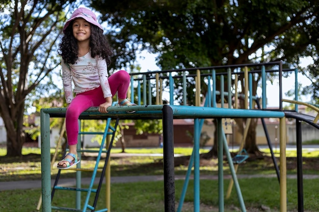 Chica latinoamericana con actitud positiva jugando en el patio de recreo