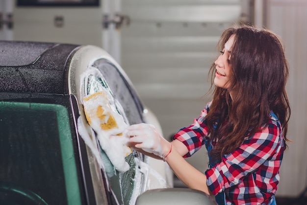 chica lavando un auto