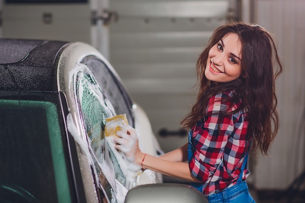 chica lavando un auto