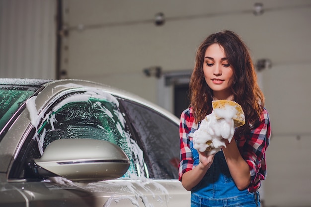 Foto chica lavando un auto