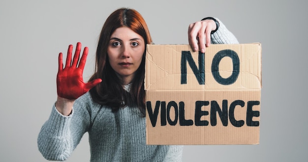 La chica levanta el cartel que dice no a la violencia y la mano con alto a la guerra en protesta