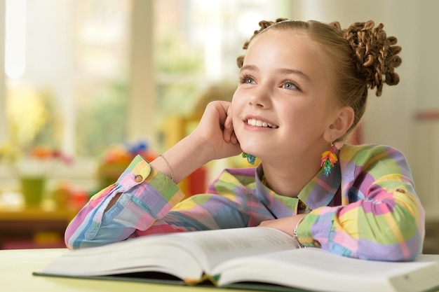 Chica leyendo un libro en la mesa