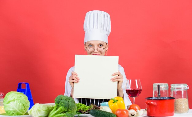 Chica leyó el libro Las mejores recetas culinarias Concepto de escuela culinaria Libro del famoso chef espacio de copia Nivel profesional Gorro y delantal de mujer estudian artes culinarias Experto culinario Chef cocinando comida saludable