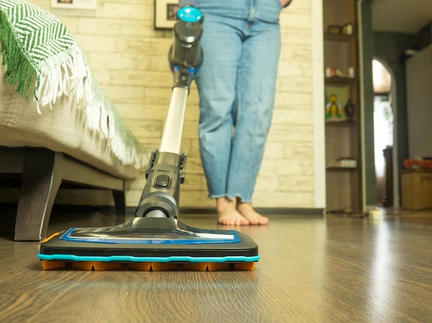 chica limpiando la casa aspirando el suelo