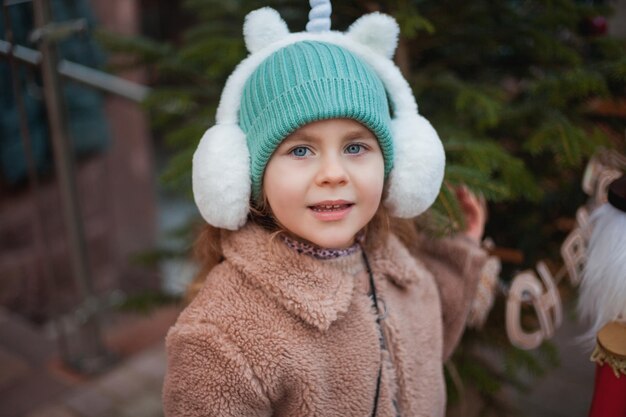 Foto chica linda de 4 años con ojos azules en un mercado europeo de navidad vacaciones año nuevo