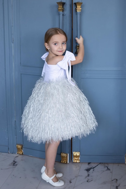una chica linda abre la puerta en una fiesta con un hermoso vestido blanco un lugar para el texto