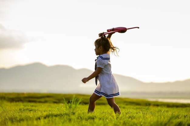 Foto una chica linda caminando por la hierba contra el cielo