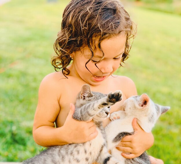 Foto chica linda sin camisa jugando con gatitos en el césped