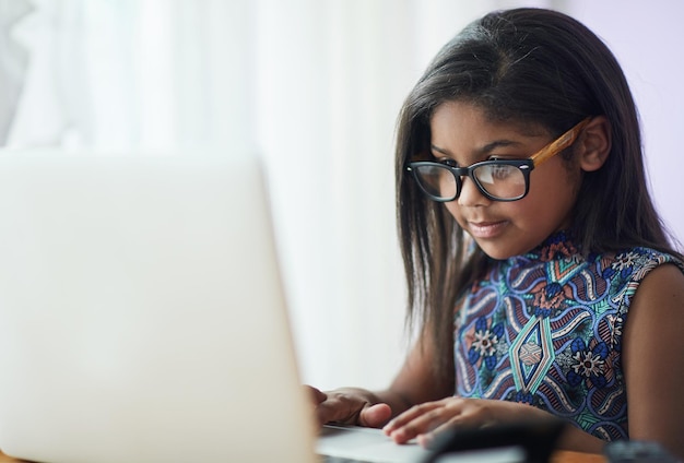 Chica linda con gafas usando una computadora portátil
