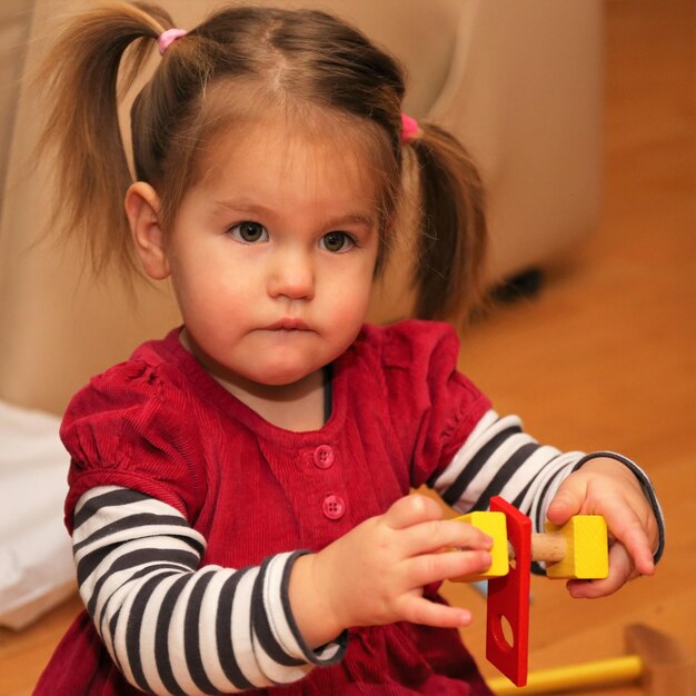 Foto una chica linda jugando con juguetes en casa.