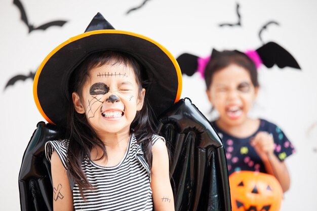 Foto chica linda y juguetona con maquillaje espeluznante en casa durante halloween