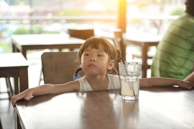 Una chica linda mirando lejos por la mesa en el café