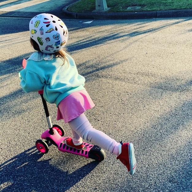 Foto una chica linda montando en bicicleta por la carretera