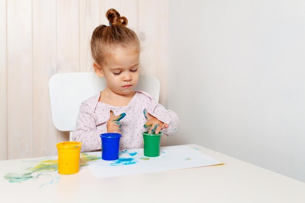 Una chica linda pintando en papel en casa