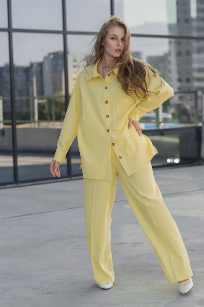 Foto chica linda en un traje amarillo de verano dama de negocios en traje de pantalón