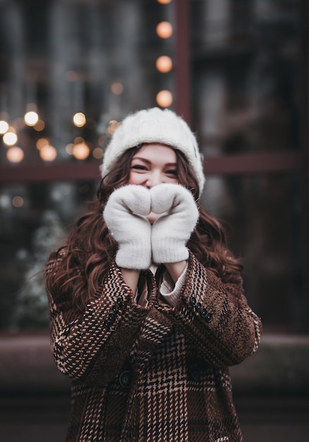 Chica en look de invierno muestra forma de corazón