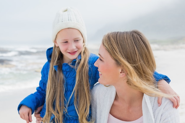 Chica con madre sonriente en la playa