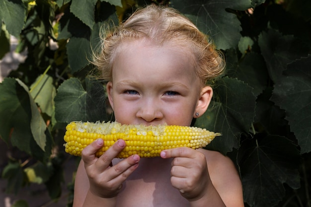 Foto chica con maíz bajo luz natural. chica con verduras. gente real.