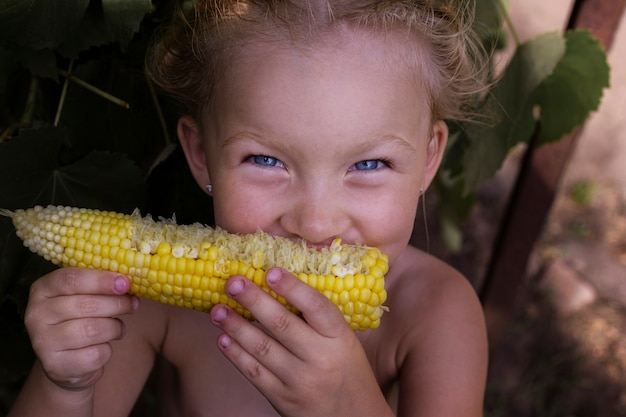 Foto chica con maíz bajo luz natural. chica con verduras. gente real.