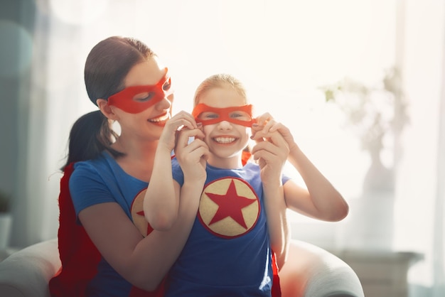 Chica y mamá en traje de superhéroe