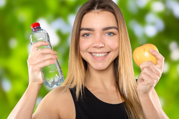 Chica con manzana y botella de agua.