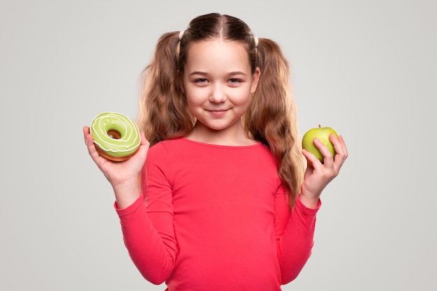 Chica con manzana verde y donut