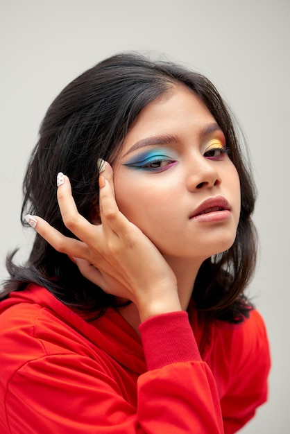 Chica con maquillaje colorido y manicura