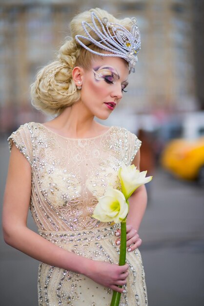 Chica con un maquillaje original en un hermoso vestido con flores.