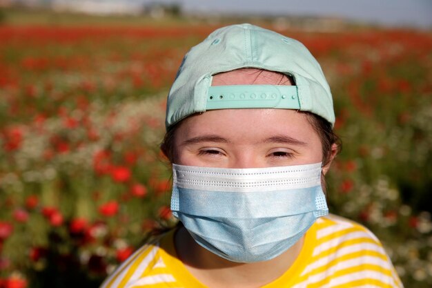 Chica con máscara en la cara en el fondo del campo de flores