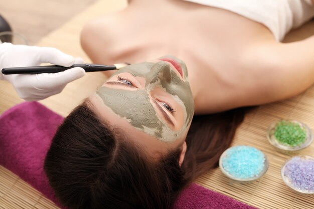 Foto chica con máscara facial en el centro de belleza spa de salud