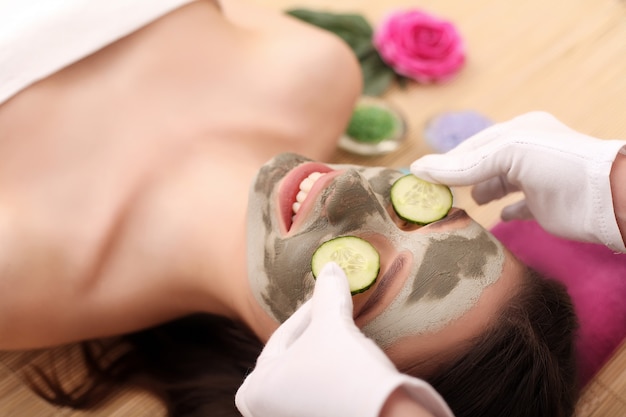 Chica con máscara facial en el centro de belleza spa de salud