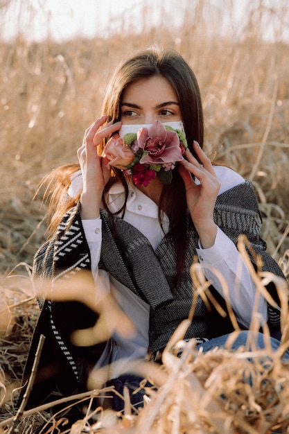 Chica en una máscara médica con flores.