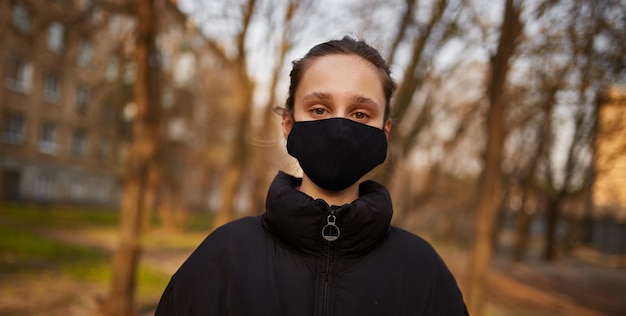 chica con una máscara médica negra en la calle cuarentena Autoaislamiento