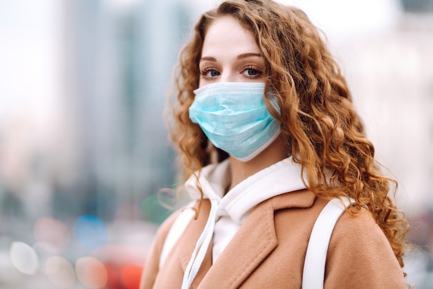 Chica en máscara médica protectora estéril en su rostro en la calle