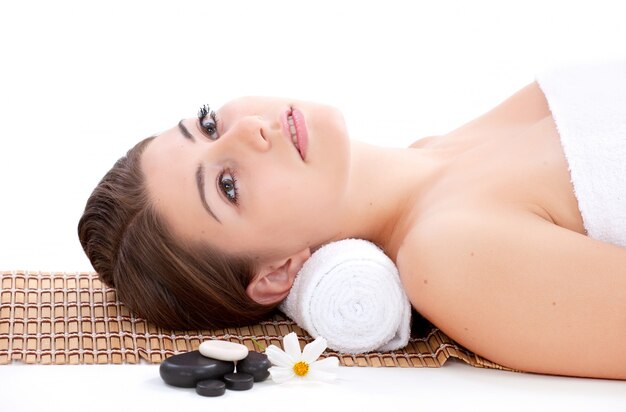 Chica con mascarilla en una terapia con piedras