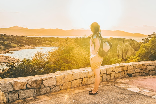 Chica mirando Capo Ferro en el Mar Mediterráneo en Costa Smeralda en Cerdeña en Italia