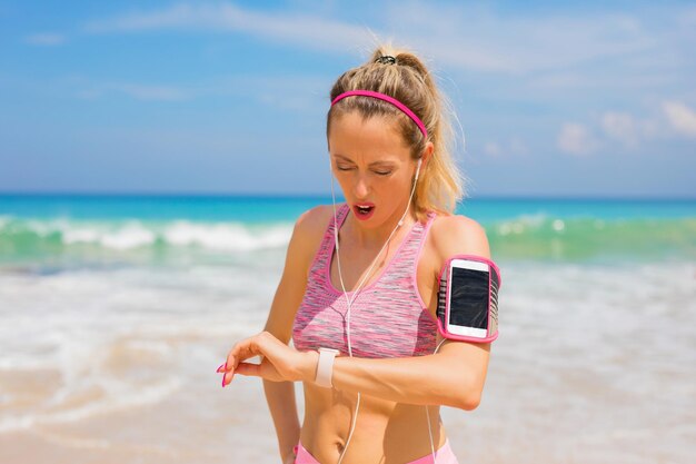 Chica mirando smartwatch durante el ejercicio físico