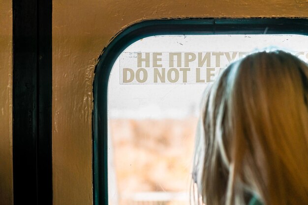 Foto chica mirando por la ventana dentro de un tren subterráneo metro disfrutando de la vista transporte