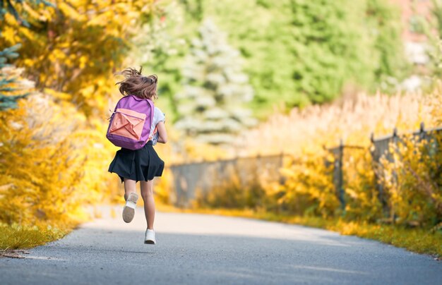 Foto chica con mochila va a la escuela.